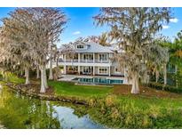 Stunning lakefront home featuring a pool, covered patio, and lush landscaping at 2118 Lake Dr, Winter Park, FL 32789