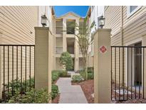 Inviting exterior of a multi-story condo building with landscaped walkway and decorative entry pillars at 404 Summit Ridge Pl # 212, Longwood, FL 32779