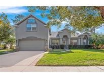 Charming two-story home with a well-manicured lawn and a two-car garage at 4251 King Edward Dr, Orlando, FL 32826