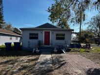 Charming single-story home featuring a red front door, brick walkway and cozy front porch at 592 N 8Th St, Eagle Lake, FL 33839