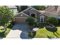 Charming single-Gathering home featuring a two-car garage and lush landscaping at 619 Blenheim Loop, Winter Springs, FL 32708