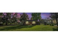Charming brick home with a lush green lawn and mature trees, offering a serene and inviting curb appeal at 651 W Lake Brantley Rd, Altamonte Springs, FL 32714