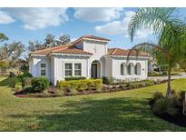 Charming single-story home featuring a terracotta roof, stucco facade, and lush landscaping at 8064 Peaceful Cir, Sanford, FL 32771