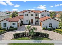 Stunning two-story home with a brick driveway, red tile roof, and elegant landscaping at 15644 Panther Lake Dr, Winter Garden, FL 34787