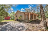 Charming one-story home with a spacious porch and a red outbuilding in a natural setting at 16318 Hamilton Dr, Orlando, FL 32833