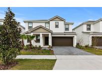 Charming two-story home with a well-manicured lawn, brown accents, and brick paver driveway at 2626 Calistoga Ave, Kissimmee, FL 34741