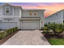 Charming two-story home featuring a paver driveway, lush landscaping, and an attached two-car garage at 2929 Satire St, Kissimmee, FL 34746