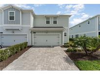 Charming two-story home with a well-manicured lawn, a paved driveway, and an attached garage at 2929 Satire St, Kissimmee, FL 34746
