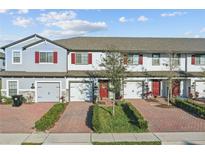 Charming townhouse featuring a brick driveway and meticulously maintained landscaping, enhancing curb appeal at 319 Smugglers Way, Apopka, FL 32712