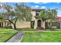 Charming townhouse featuring a red tile roof and well-manicured lawn at 451 Hunter Cir, Kissimmee, FL 34758