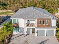 Stunning two-story home with a modern design, a balcony, three-car garage, and manicured landscaping at 480 Muirfield Loop, Reunion, FL 34747