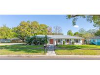 Charming single-story home featuring a well-manicured lawn and a durable metal roof at 5121 Hoperita St, Orlando, FL 32812