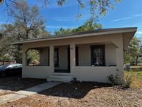 Charming single-story home featuring a cozy covered front porch and ample natural light from windows at 542 N 8Th St, Eagle Lake, FL 33839