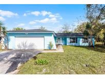 Charming, light-blue single-story home featuring an attached two-car garage and landscaped front yard at 1117 N Hart Blvd, Orlando, FL 32818