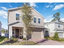 Charming two-story home boasts a neutral stucco facade, complemented by stone accents and a brick driveway at 1129 Blue Garden Dr, Deland, FL 32720