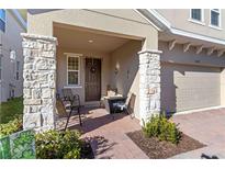 Inviting front porch with stone pillars and a cozy seating area, perfect for relaxing and enjoying the neighborhood at 1129 Blue Garden Dr, Deland, FL 32720