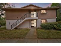 Inviting two-story exterior featuring well-maintained siding, trimmed bushes, and a staircase leading to the upper level entrance at 170 Palmetto Woods Ct # 3A, Deltona, FL 32725