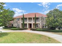 Stunning two-story home boasting a terracotta roof, lush landscaping, and a circular driveway at 3414 Cocard Ct, Windermere, FL 34786
