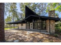 Striking mid-century modern home showcasing a unique roofline, stone chimney, and expansive windows at 812 2Nd St, Altamonte Springs, FL 32701