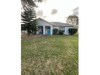 Charming single-story home features a well-manicured lawn and a bright blue front door at 12538 Indiana Woods Ln, Orlando, FL 32824