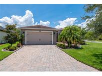 Charming single-story home featuring a two-car garage and a paved driveway with manicured landscaping at 1368 Del Mar Dr, Kissimmee, FL 34759