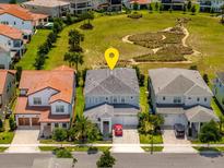 An aerial view of a two-story home featuring well-maintained landscaping and proximity to a neighborhood park at 15724 Cutter Sail Pl, Winter Garden, FL 34787