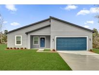 Charming single story home with gray stucco, blue front door, and well-manicured lawn at 2415 Sw 165Th Pl, Ocala, FL 34473