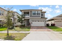 Beautiful two-story home featuring a modern design, two-car garage, and well-maintained lawn at 2546 Empress Dr, Kissimmee, FL 34741