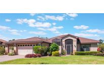 Charming single story home with manicured lawn, attached garage, and beautiful, colorful landscaping at 27307 Pine Straw Rd, Leesburg, FL 34748