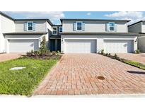 Charming townhomes featuring brick driveways, blue shutters, and well-maintained landscaping at 4365 Switchgrass Ln, St Cloud, FL 34772