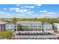 Three-story condo building with central parking, lush landscaping, and partial cloudy sky at 660 Celebration Ave # 220, Kissimmee, FL 34747