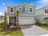 Charming two-story home featuring a two-car garage, well-manicured landscaping, and a welcoming entrance at 7180 Oakmoss Loop, Davenport, FL 33837