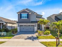 Charming two-story home with a well-manicured lawn and a two-car garage at 8743 Sidley Ln, Orlando, FL 32832
