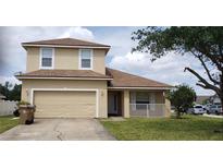 Two-story home showcasing a well-maintained lawn, a two-car garage, and neutral-toned exterior paint at 2711 Eagle Creek Ct, Kissimmee, FL 34746