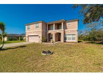 Charming two-story home with a spacious front yard, covered entryway, and attached two-car garage at 1905 Snapper Dr, Kissimmee, FL 34759