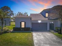 Charming home featuring a two-car garage, lush landscaping, and a well-manicured lawn in a desirable neighborhood at 20604 Maxim Pkwy, Orlando, FL 32833