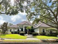 Charming single-story home featuring a manicured front lawn, mature trees, and a tile roof at 307 Running Wind Ln, Maitland, FL 32751