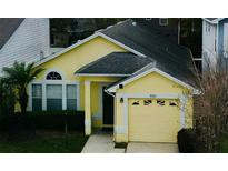 Charming single-story home with a one-car garage, manicured lawn, and light yellow paint at 3361 Hamlet Loop, Winter Park, FL 32792