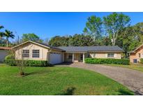 Charming single-story home with well-manicured lawn, brick driveway and attached garage at 519 Cornwall Rd, Winter Park, FL 32792