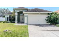 Charming single-story home featuring an attached two-car garage and a well-maintained lawn at 8822 Fort Jefferson Blvd, Orlando, FL 32822