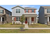 Two-story home with red shutters and a well-manicured lawn showcases charming curb appeal at 11356 Sunsail Ave, Orlando, FL 32832
