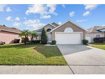 Charming single-story home with a well-manicured lawn, mature landscaping, and a two-car garage at 2524 Monaco Cove Cir, Orlando, FL 32825