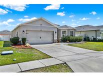 Attractive single-story home with a spacious driveway, lush lawn, and well-maintained landscaping at 3086 Brenton Manor Loop, Winter Haven, FL 33881