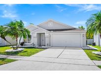 Charming single-Gathering home featuring an attached two-car garage, manicured lawn, and verdant tropical landscaping at 3156 Natoma Way, Orlando, FL 32825