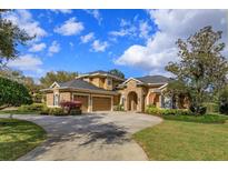 Stunning home featuring a stone archway entry, three-car garage, beautiful landscaping, and a circular driveway at 1704 Kersley Cir, Lake Mary, FL 32746