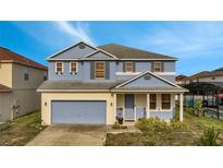 Charming two-story home featuring a covered entry, attached garage, and manicured lawn at 1735 Pine Ridge Dr, Davenport, FL 33896