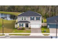 Beautiful two-story home with a well-manicured lawn and a brick paver driveway and two-car garage at 2984 Sanctuary Dr, Clermont, FL 34714