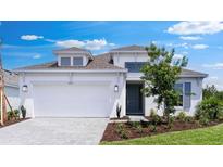 Charming, modern white home with a two car garage, neat landscaping, and a welcoming entrance at 4192 Barbuda Ln, Kissimmee, FL 34758