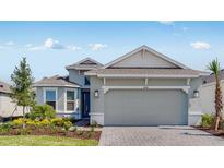 Charming single-story home featuring a two-car garage, paver driveway, manicured landscaping, and a neutral color palette at 4198 Barbuda Ln, Kissimmee, FL 34758