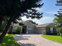 Charming single-story home features a brick driveway, attached garage, and well-maintained landscaping at 4847 Lake Milly Dr, Orlando, FL 32839